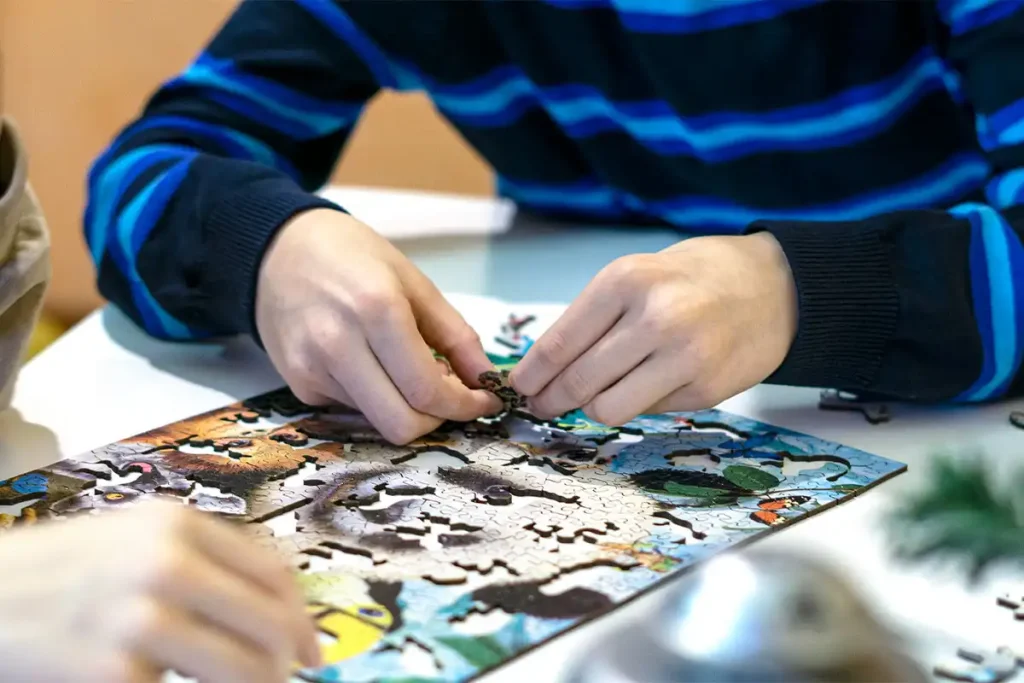 Boy Putting Together Wooden.City Puzzle